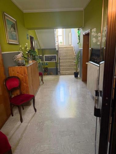 a hallway with green walls and a red chair and stairs at Villa Santa Chiara in Loreto