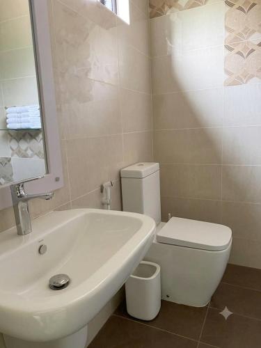 a bathroom with a white toilet and a sink at ANABEE HOLIDAY Inn in Jaffna