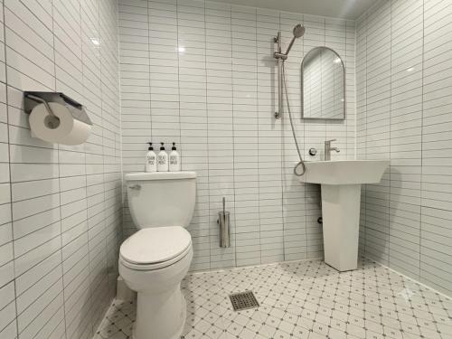 a white bathroom with a toilet and a sink at Stay brick in Seoul