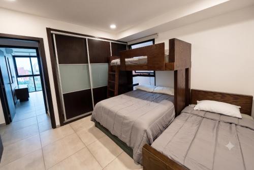 a bedroom with two bunk beds in a room at Departamento de lujo en Col Americana con alberca in Guadalajara