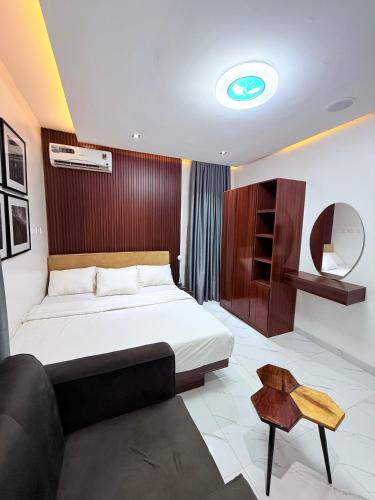 a bedroom with a bed and a table in it at SereneHiz Shelters in Enugu