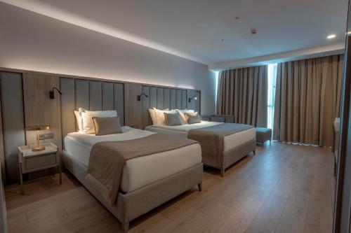 a hotel room with two beds and a window at RENEX HOTELS in Antalya