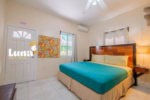 a bedroom with a large bed and a door at BELIZE TROPICAL DREAM VILLAS in San Pedro