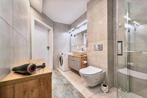 a bathroom with a toilet and a glass shower at Apartament Kaskady75 in Łańcut