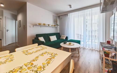 a living room with a green couch and a table at Apartament Kaskady75 in Łańcut