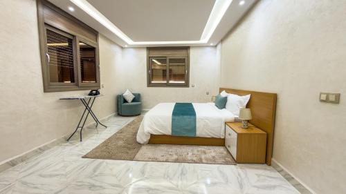 a bedroom with a bed and a table and windows at Lagoon House Dakhla in Dakhla