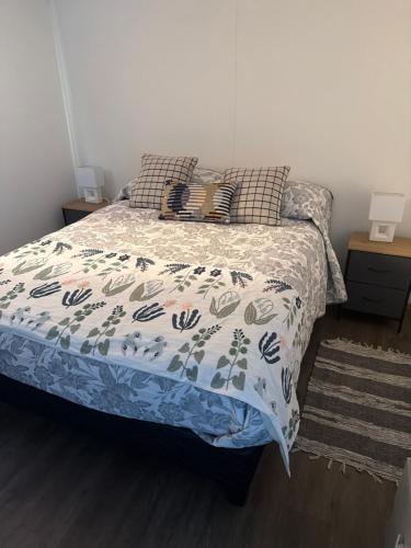 a bedroom with a bed with a blue and white comforter at Casa monje Patagonia in Puerto Natales