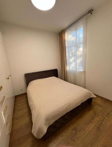 a small bedroom with a bed and a window at Modern apartment in Klaipėda