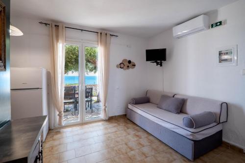 a living room with a couch and a television at Corfu Glyfada Beach Apartment 24 in Glyfada