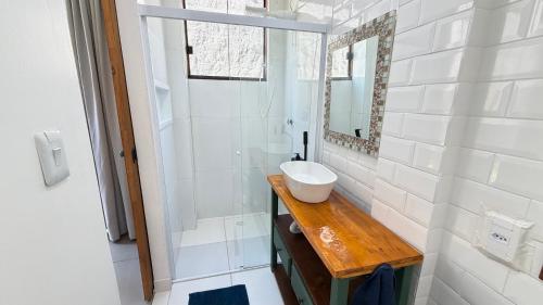a bathroom with a sink and a mirror at Makai Suites in Ubatuba