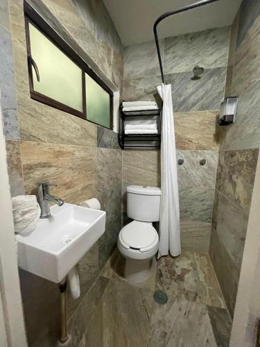 a bathroom with a toilet and a sink at Hotelito Lindo León in León
