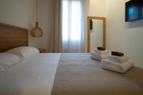 a bedroom with a bed with towels on it at Hotel Cas Ferrer Monjo in Ciutadella