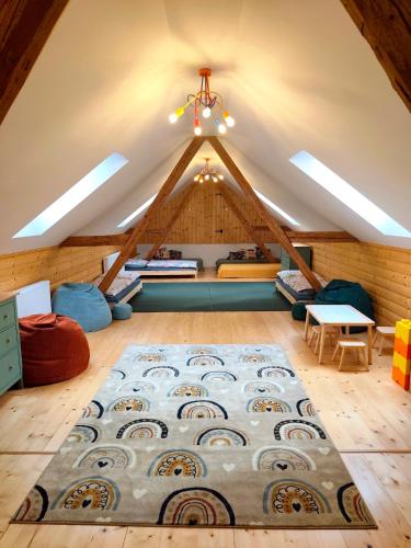 an attic room with a large rug on the floor at Statek u Juzů in Dolní Újezd