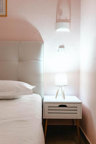 a bedroom with a bed and a lamp on a night stand at Corfu Glyfada Beach Apartment 40 in Glyfada