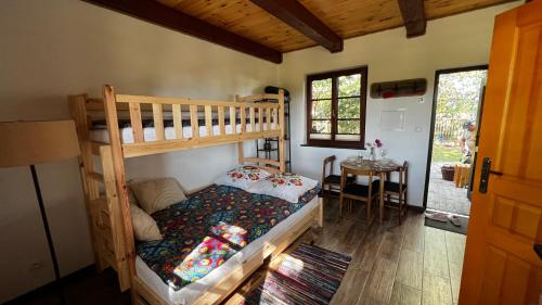 a bedroom with two bunk beds and a table at Domek 2-3 osobowy in Lejno