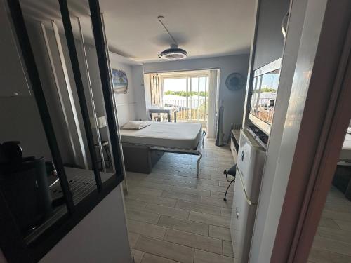 a room with a bedroom with a bed and a window at L'Acropole in Cap d'Agde