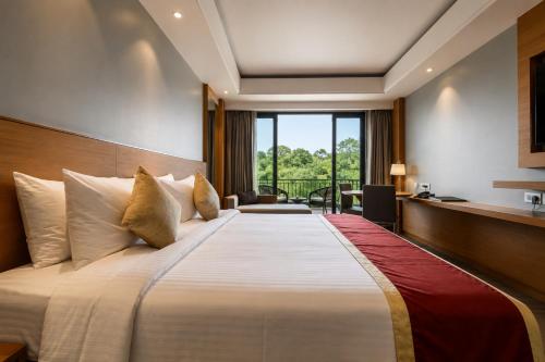 a large bed in a hotel room with a window at Kiranshree Grand in Guwahati