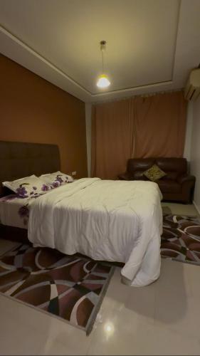a bedroom with a white bed and a rug at nouhaila Lag in Rabat