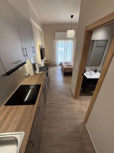 a kitchen with a sink and a living room at Above Apartments near the Airport in Artemida