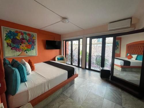 a bedroom with two beds and a balcony at Hotelito Lindo León in León