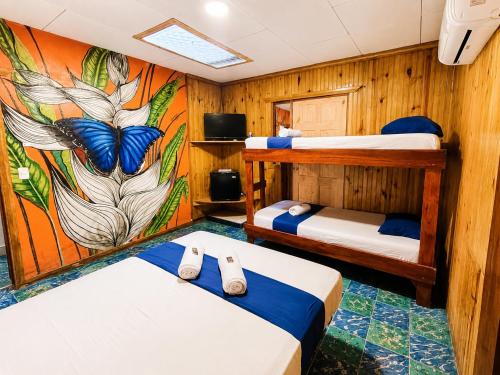 a room with three beds and a mural on the wall at Casa Dolce Vita in Puerto Viejo