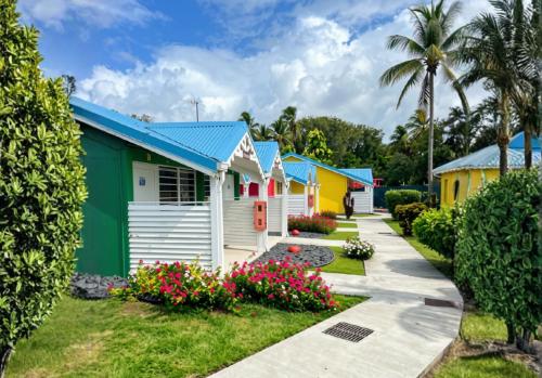 eine Reihe bunter Ferienhäuser in einem Ferienort in der Unterkunft Hotel Le Rotabas in Sainte-Anne