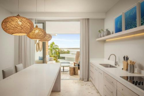 a kitchen with a white counter and a view of the ocean at Alaia Belize, Autograph Collection in San Pedro