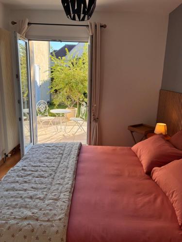 a bedroom with a bed and a door to a patio at Orée de Villevert in Senlis