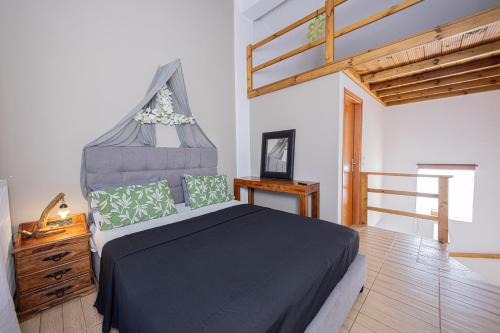 a bedroom with a large bed and a wooden floor at Irene's Maisonette at Rafaella Resort in Kokóni