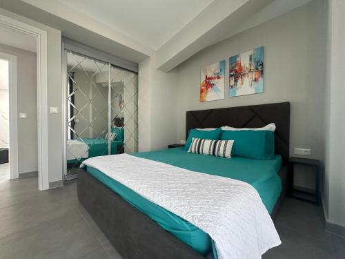 a bedroom with a large bed with blue and white sheets at Villa Sunset in Yerakiní