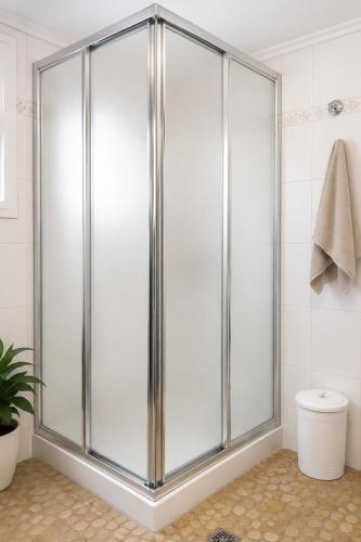 a glass shower in a bathroom with a toilet at Ozias House in Oziás
