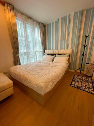 a bedroom with a bed in a room with a window at Beautiful Sandy Jomtien Beach Pattaya at NeO Seaview Condo in Jomtien Beach