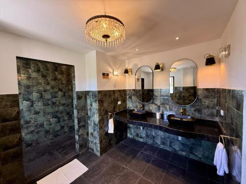 a bathroom with two sinks and two mirrors at Hotel Villa Toti in Santa Verónica