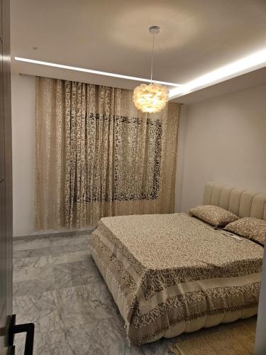 a bedroom with a bed and a chandelier at Casa marsa in Gammarth