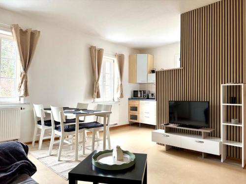 a living room with a table and a television at Süße Wohnung im Grünen in Weiler