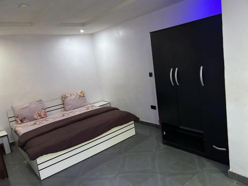a bedroom with a bed and a black cabinet at Cozy Nooks in Ijaiye