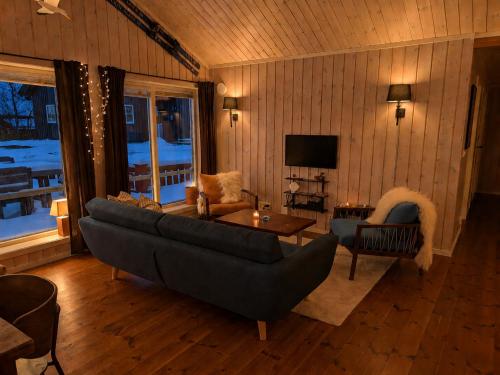 a living room with a couch and a table at Håvi Solsiden 11C in Trysil