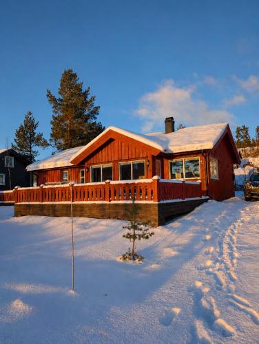 a large wooden house with snow on the ground at Håvi Solsiden 11C in Trysil