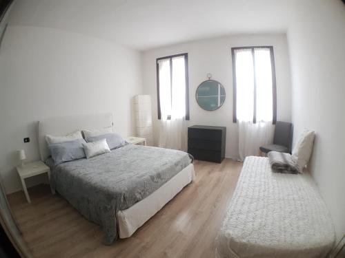 a white bedroom with a bed and a chair at Cà Marta in Venice
