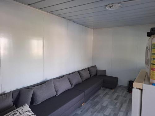 a couch in a room with a white wall at Cuki Apartmanház in Sarud