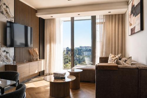 a living room with a couch and a large window at On Park 516 At Century City in Cape Town