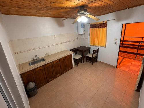 a kitchen with a sink and a table and a table at Borus Hostel in Puerto Iguazú