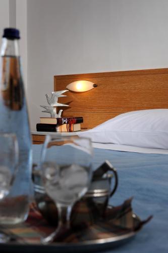 a plate with a bottle and glasses on a table at Delfinia Hotel & Bungalows in Mithymna