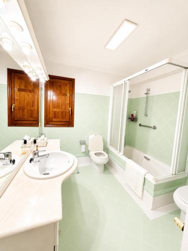 a bathroom with a sink and a toilet and a shower at Casa Canciones in Alzira
