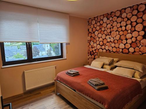 a bedroom with a bed with a large logs wall at WOLL Forest in Schmallenberg
