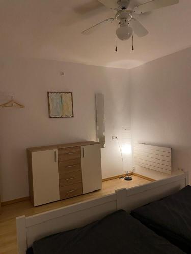 a bedroom with a dresser and a ceiling fan at Ferienwohnung Burgstadt Kastellaun in Kastellaun