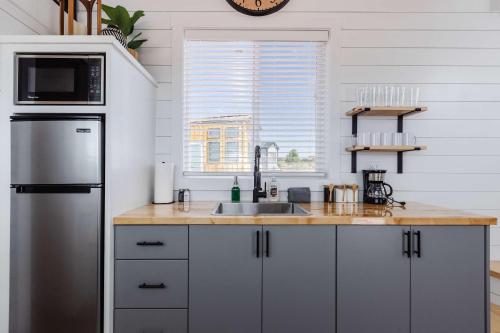 a kitchen with a stainless steel refrigerator and a sink at Zion Basecamp Private Hot Tub Near Trails in Apple Valley