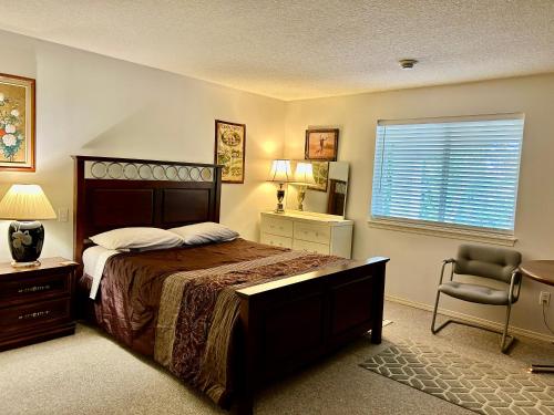 a bedroom with a bed and a chair and a window at Red Robe Chamber in Nanaimo