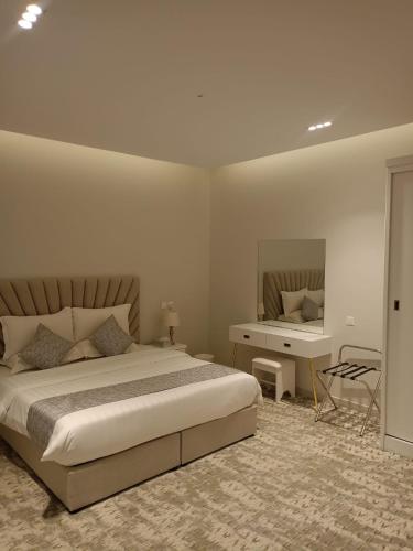 a bedroom with a bed and a desk in it at استراحات وفلل رفايا in Abha