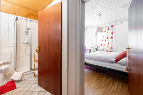 a bathroom with a shower and a bed in a room at Café Marie - Bed & Breakfast in Eggersdorf bei Graz